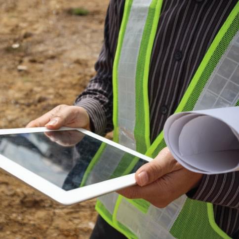 worker holding tablet with land and asset management software