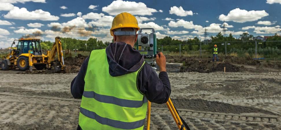 man doing land surveying using MaintStar Land Management system software