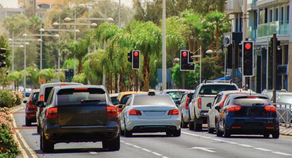 cars on city street stopped at traffic light